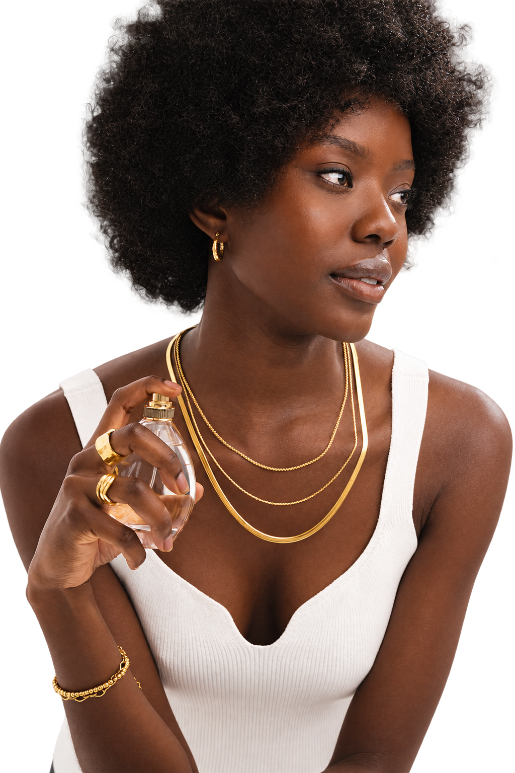 Woman wearing gold jewelry and holding a perfume bottle